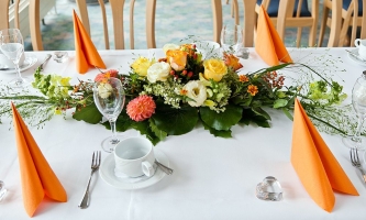 Gedeckter Kaffeetisch im Restaurant mit Blumenschmuck 