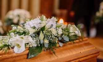 Mit weißen Blumen geschmückter Sarg in einer Kirche 