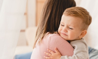 Baby klammert sich weinend an Mutter 