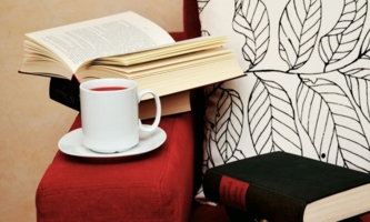 Bücher und Tasse Tee auf Sofa 