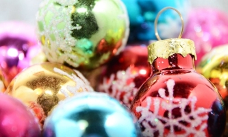 Viele bunte glänzende Christbaumkugeln liegen auf- und nebeneinander herum