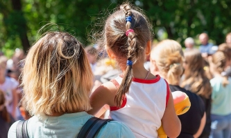 Mutter und Kind in Menschenmenge bei Veranstaltung im Freien 