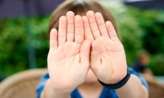 Kinderhände in Abwehrhaltung vor dem Gesicht