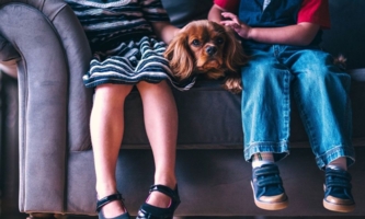 zwei Kinder mit Hund auf Sofa 