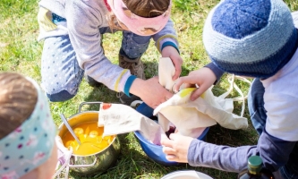 Kinder färben Eier auf Wiese