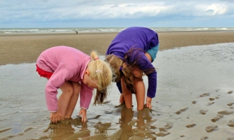 Zwei Kinder spielen am Strand im Sand