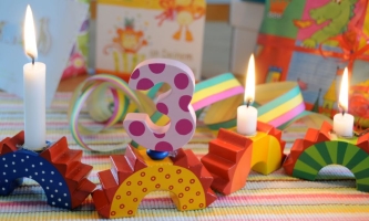 Dekoration zum Kindergeburtstag mit Geschenken und drei Kerzen