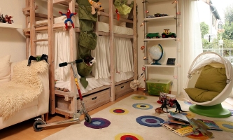 Kinderzimmer mit Bett, Sesseln, Spielsachen und Roller 