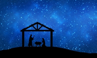 Stall mit Maria Josef und Jesuskind vor blauem Himmel mit Sternen