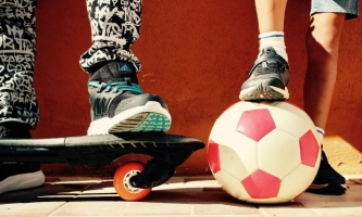 Kinderfüße auf Skatebord, Kinderfüße auf Fußball 