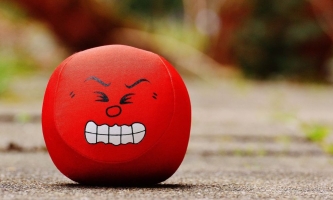 roter Antistressball mit wütendem Gesicht 