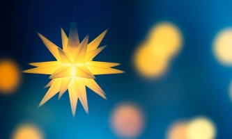 Gelber Stern leuchtet hell vor blauem Hintergrund 