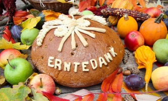 Dekorativer Aufbau aus Gemüse, Obst und einem Brot mit Aufschrift Erntedank