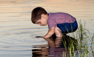 Junge spielt am Wasser