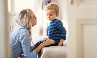 Mutter spricht mit kleinem besorgt wirkenden Sohn 