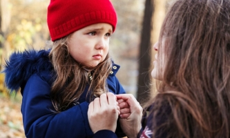 Trauriges Mädchen hält Hände der Mutter