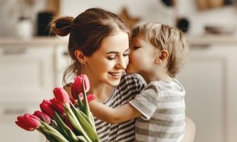 Mutter und Kind liebevoll mit Blumenstrauß