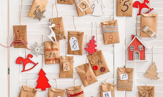 Adventskalender aus an Schnüren aufgehängten Papiertütchen mit Beschriftung und Dekoration