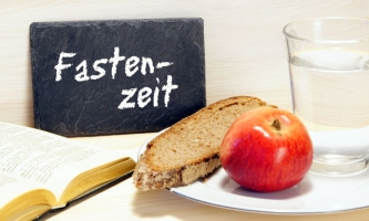 Brot, Apfel, Bibel, Wasser und Schild mit Aufschrift Fastenzeit