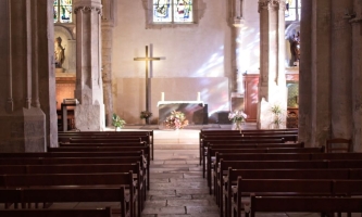 Leere Kirche in die Sonnenlicht durch die bunten Fenster fällt