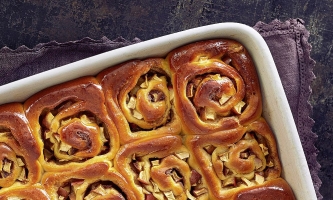 Frisch gebackene Schnecken in Auflaufform auf Holztisch 