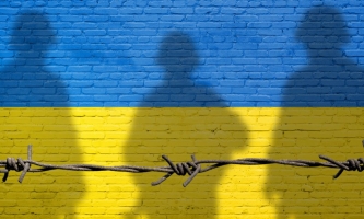Farben blau und gelb der ukrainischen Flagge mit Stacheldraht und Schatten von drei Soldaten