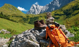Wanderschuhe und Rucksack vor Bergpanorama