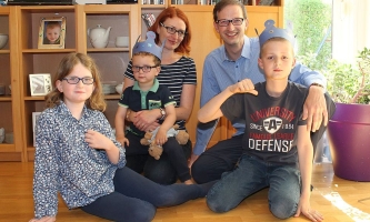 Vater und Mutter Gergen mit ihren drei Kindern im Wohnzimmer 