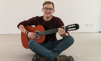 Ehemaliger FSJ-ler Lukas Werner mit Gitarre 