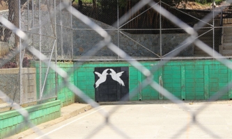 Sportplatz mit Bild von Friedenstauben auf einer Mauer 