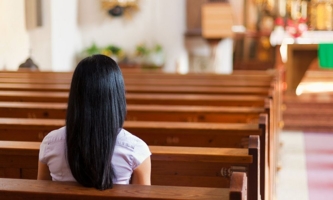 Frau sitzt in Kirche 