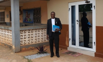 Pater Robertson Sung vor Haus in Ghana 