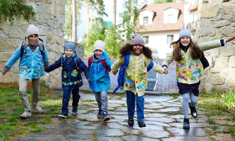 Kinder halten sich an den Händen und rennen über Gehweg 