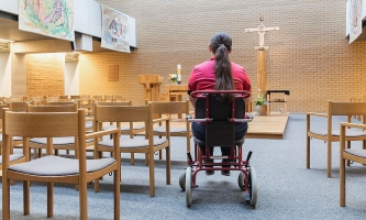 Frau im Rollstuhl in der Klinikkirche des Klinikums der Universität Großhadern in München 