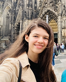Jugendliche mit braunen langen Haaren vor Kölner Dom