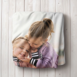 zusammengefaltete Decke mit aufgedrucktem Foto von zwei Kindern
