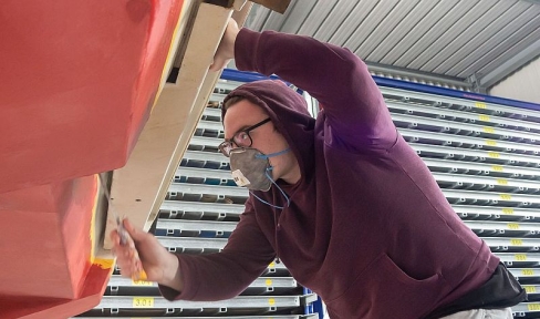 Jugendlicher arbeitet in Werkstatthalle mit Schraubenzieher an der Don Bosco Fähre