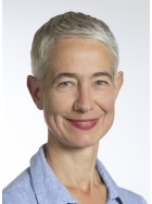 Freundlich l&auml;chelnde Frau mit kurzen grauen Haaren und hellblauer Bluse